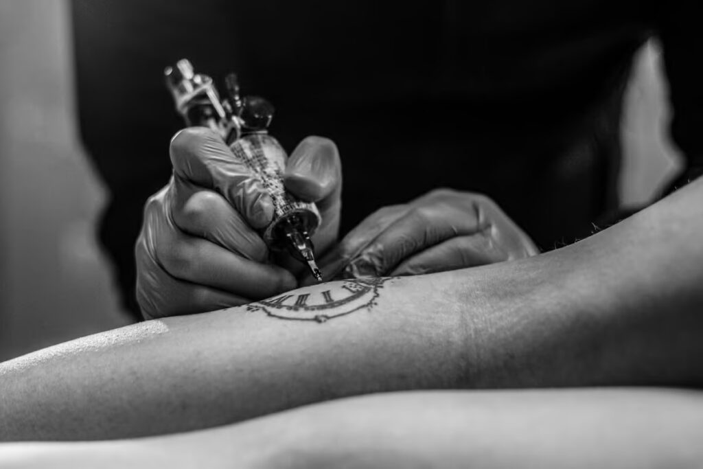 tatuador-tatuando-a-panturilha-de-um-cliente tatuador-tatuando-a-panturilha-de-um-cliente