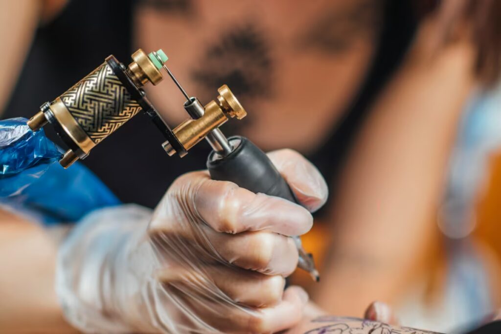 tatuadora-tatuando-o-antebraço-de-um-cliente tatuadora-tatuando-o-antebraço-de-um-cliente